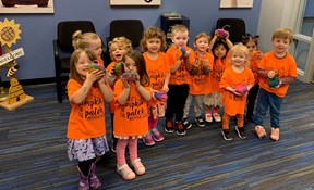 Preschoolers holding pumpkins